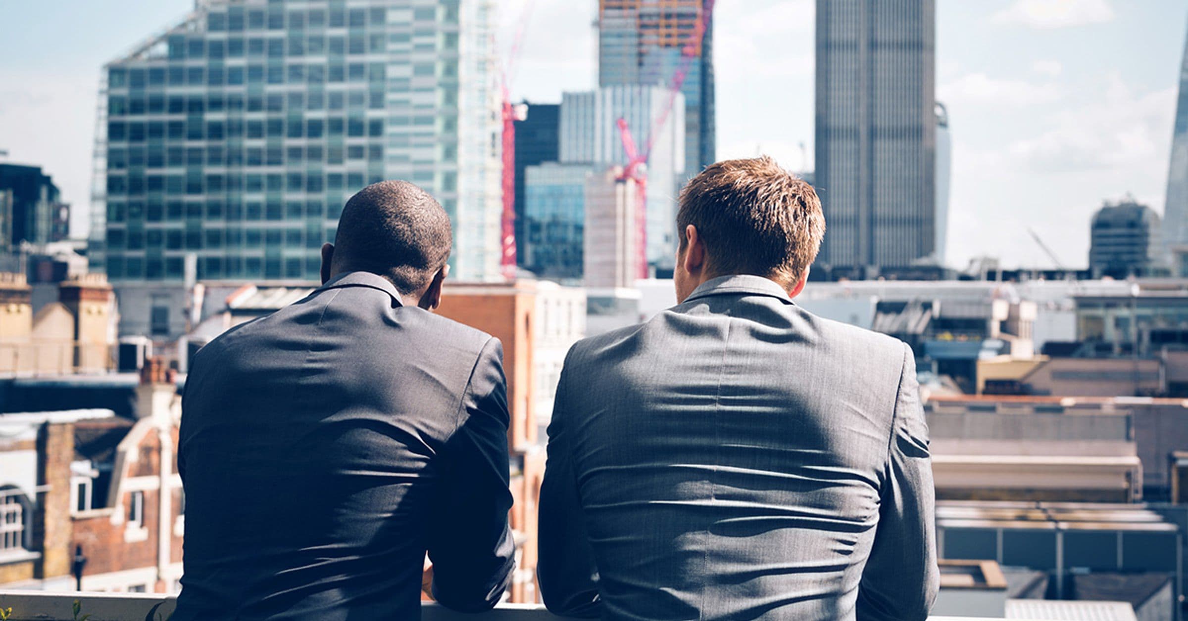 Gentlemen talking facing skyline