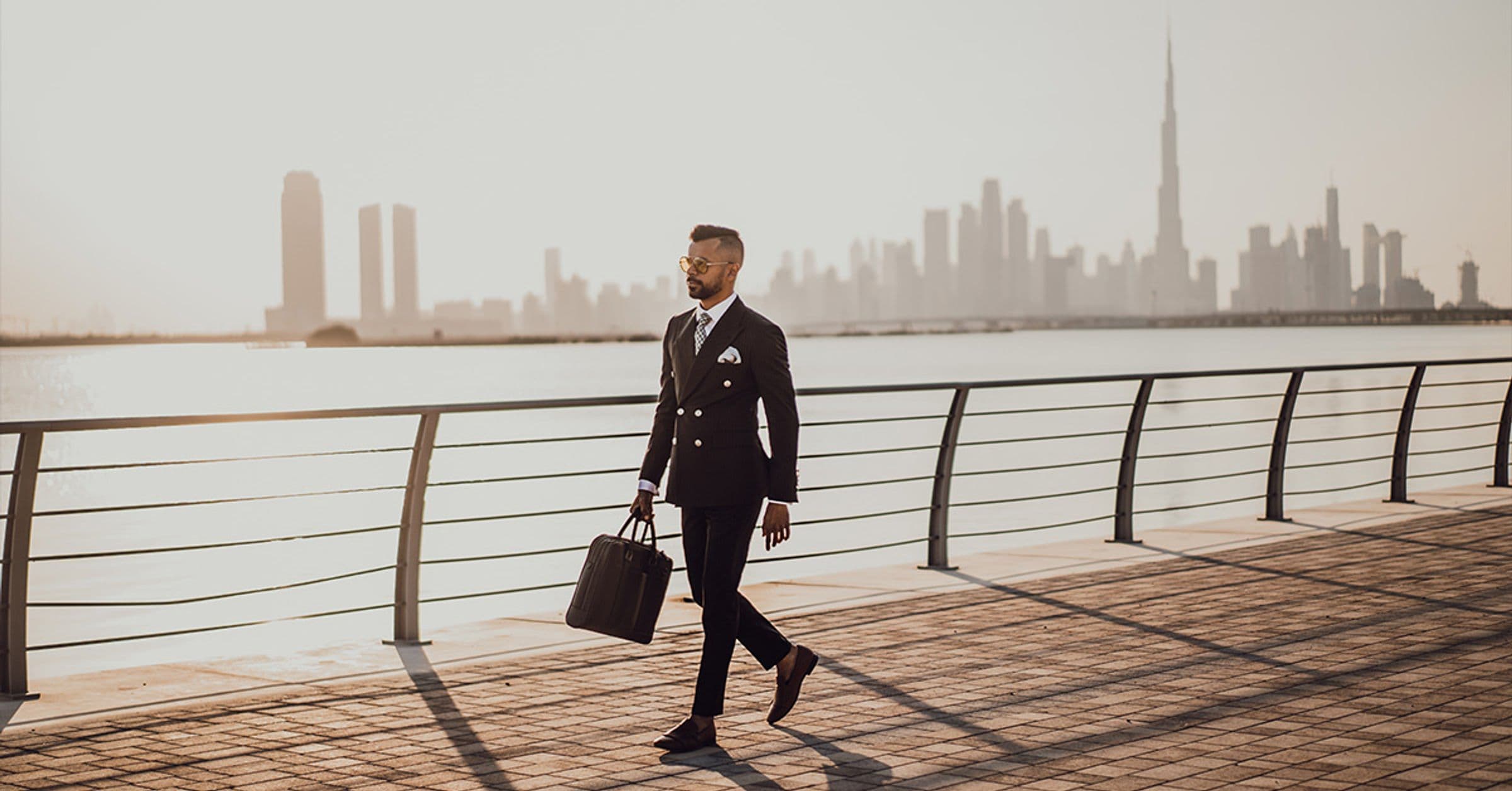 Suited man walking along waterfront